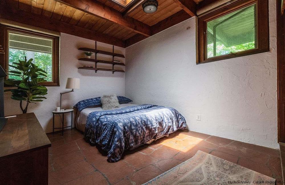 a bedroom with two windows