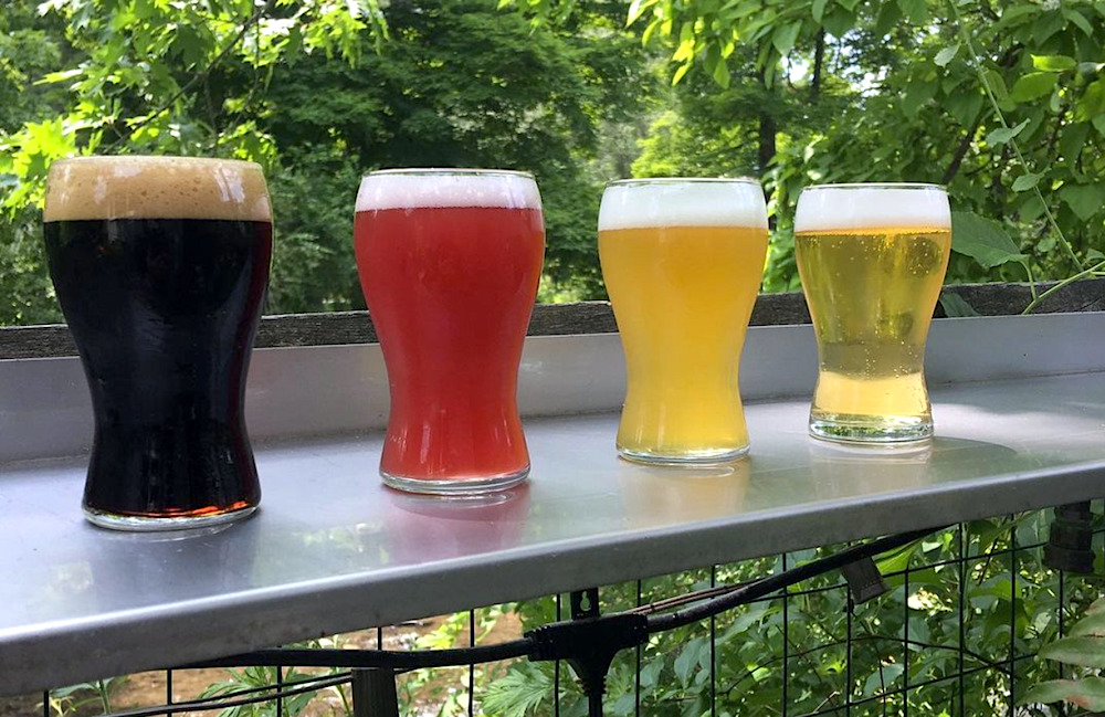 flight of different kinds of beer on the shelf outside