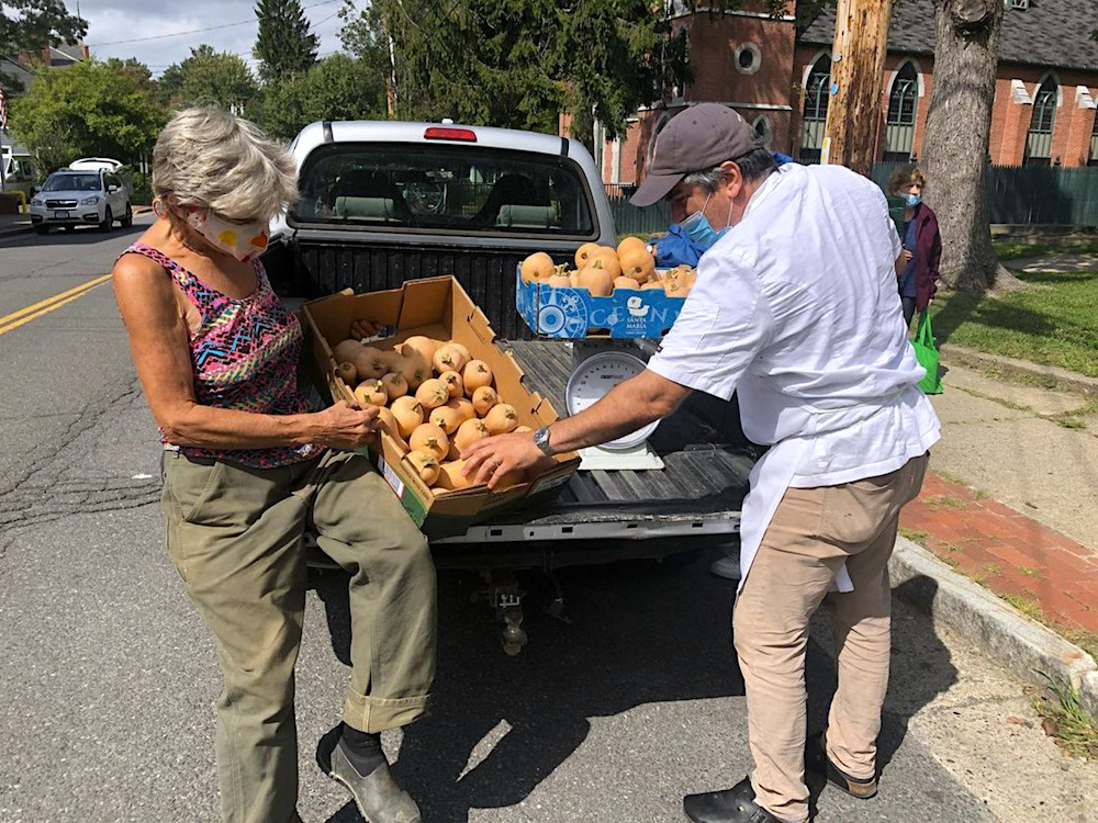 woman and Chef pulling boxes of produce from the back of a truck