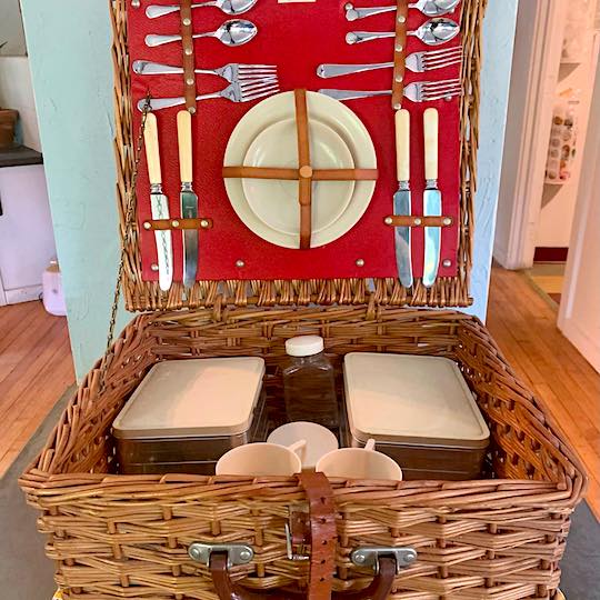 picnic basket with red interior and full plates and silverware