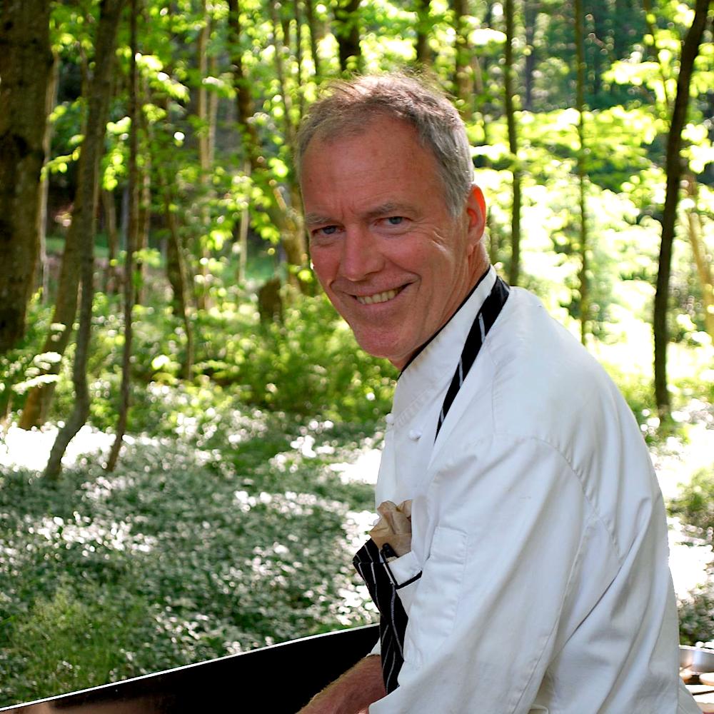 Chef Richard Erickson grilling food with nature in the background