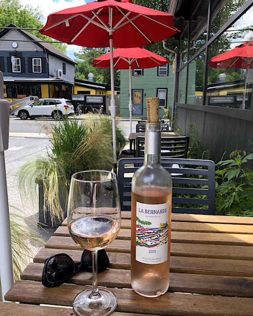 Bottle and glass of rose wine on the deck table