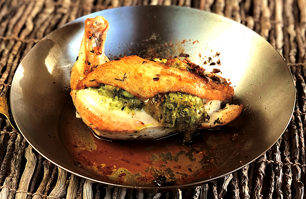 Delicious herb stuffed chicken leg golden and crispy in a pan