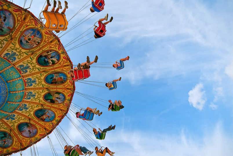 shot of a carnival swing ride from below looking up into the sky