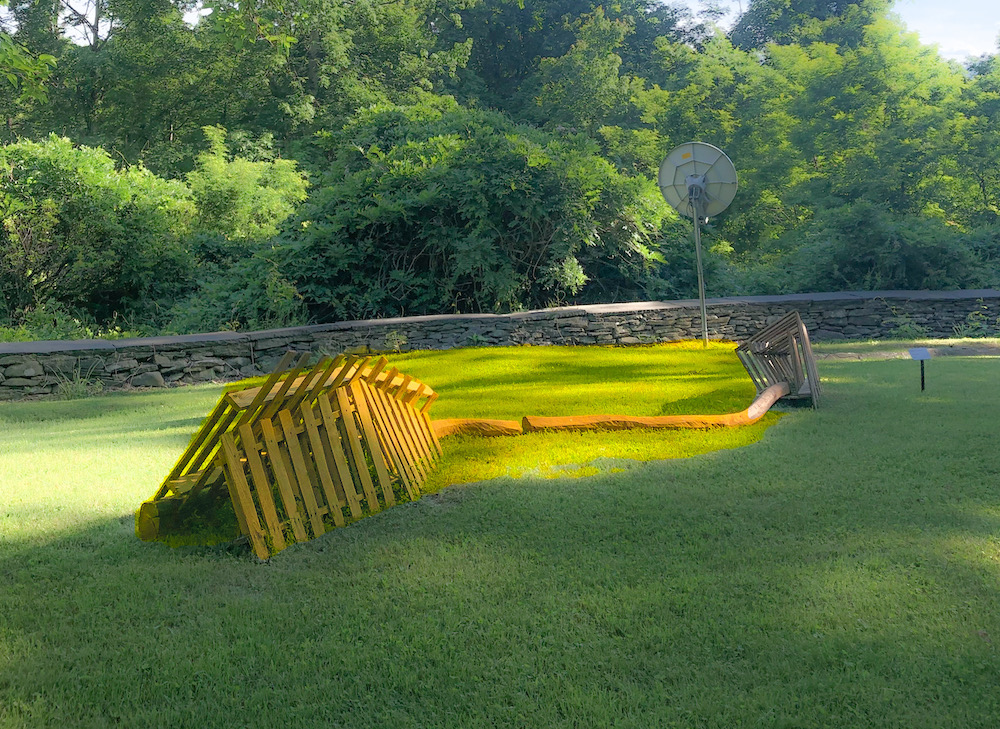 sculpture og yellow washed wooden planks in the form of a large skeleton remains of an animal