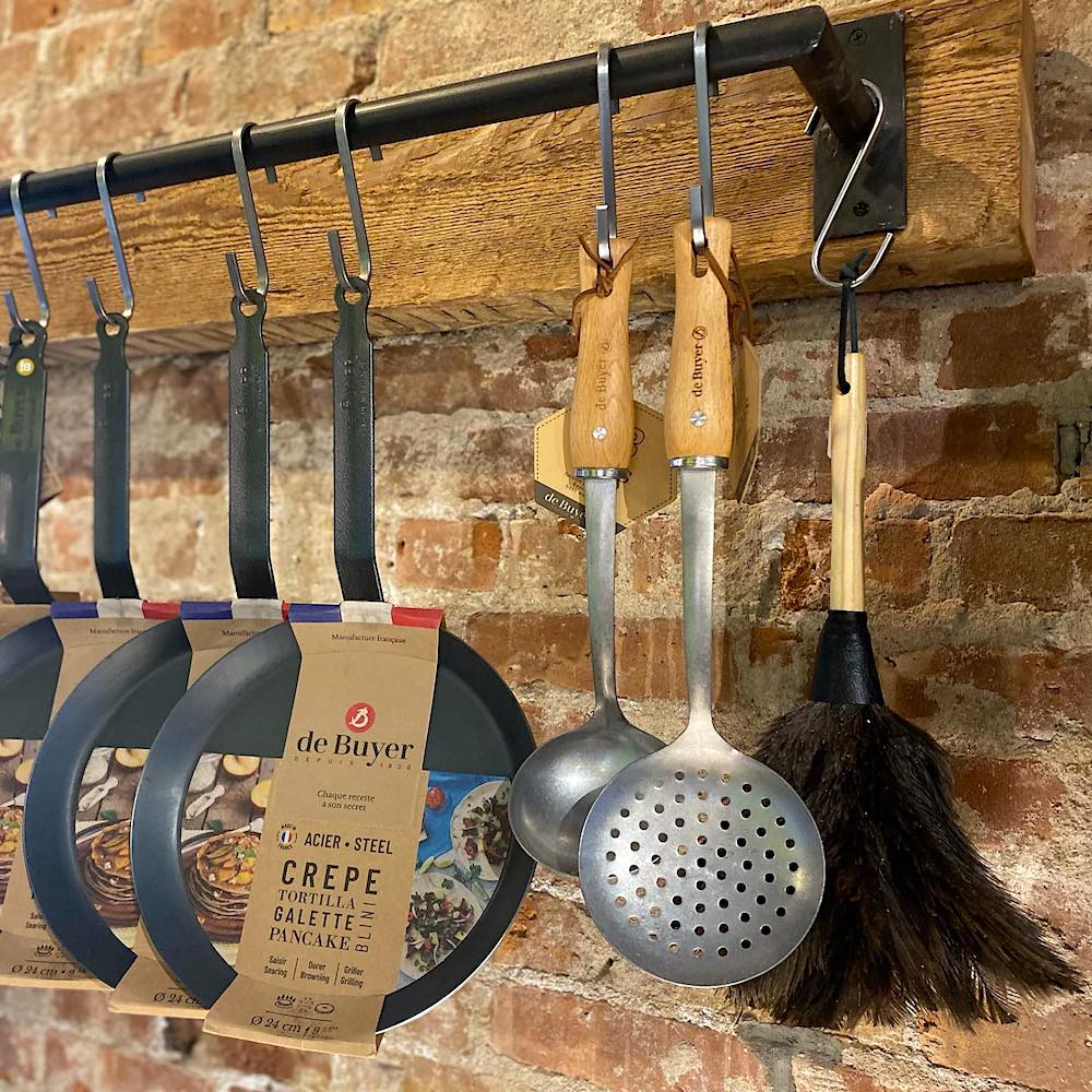 pans and kitchen tools hanging on a rack