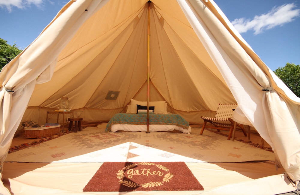 glamping tent with welcome mat and bed