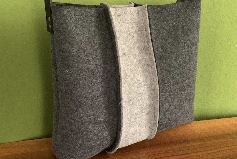 two toned grey wool felt designer bag with green background