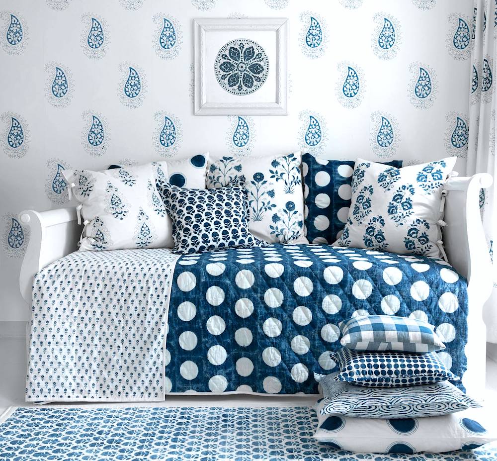 white and blue ornate bedding and wallpaper