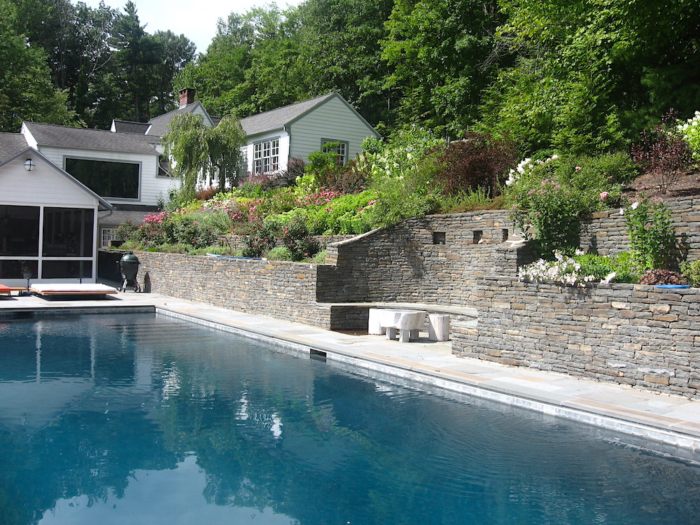 pool side with stone wall and garden