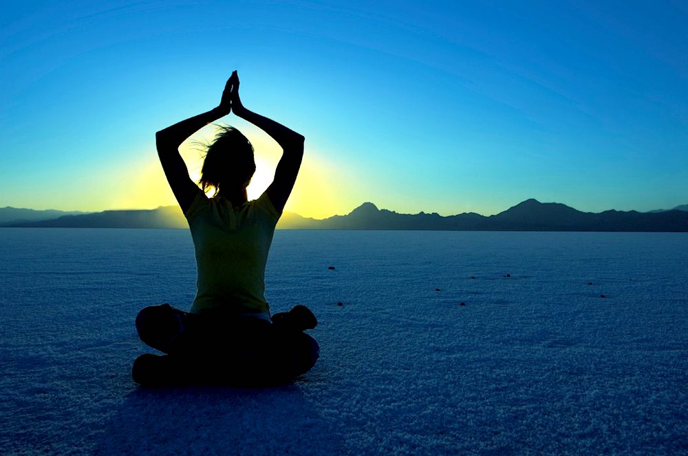 person in a yoga pose at sunset