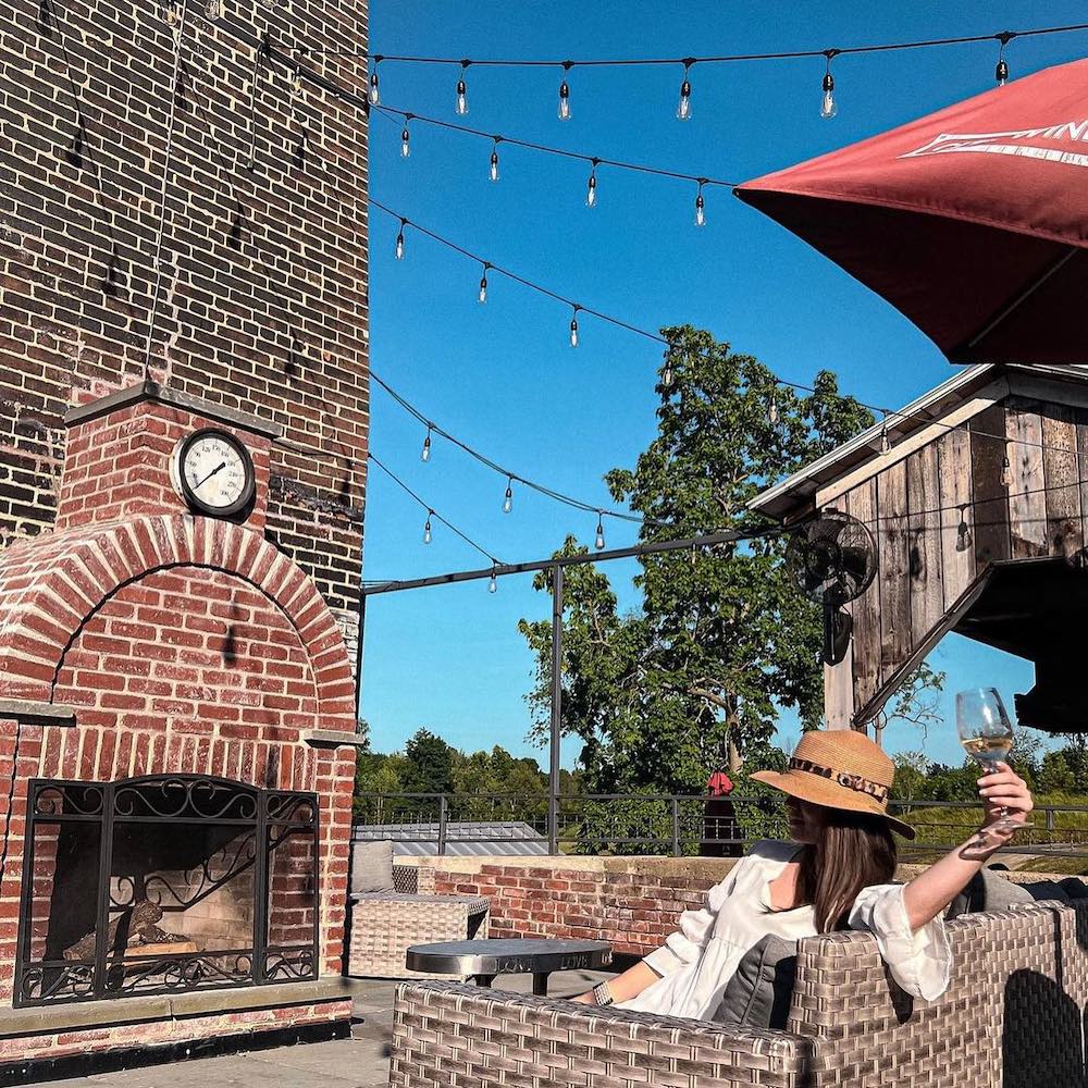 woman outside by brick fireplace