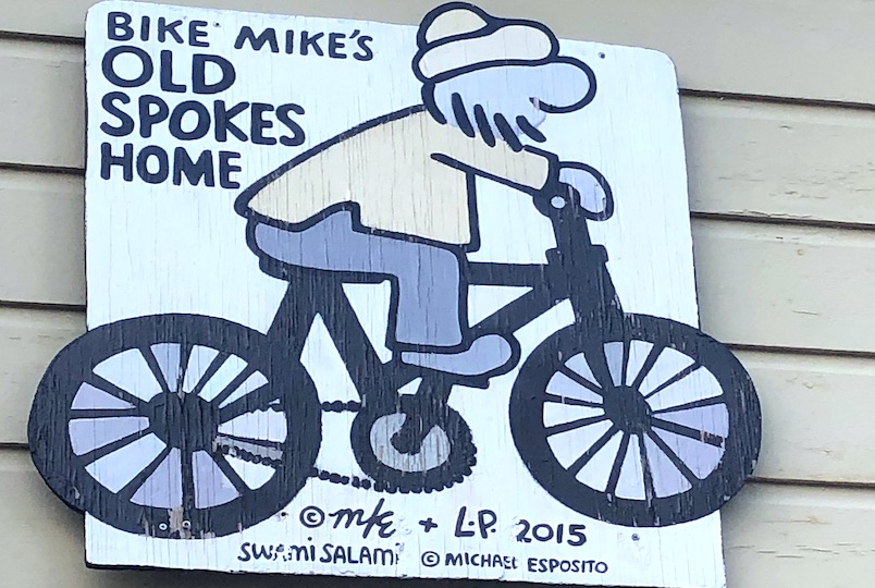 a character of a man on a bike as the logo for Old Spokes Home