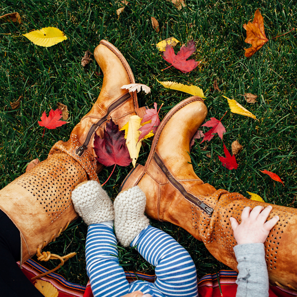 Mom and baby sitting on lawn with Fall leaves