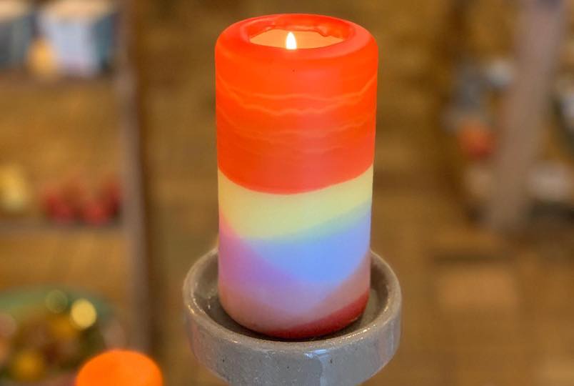 Rainbow-colored lit candle in a store at Hill Valley Candles in Kingston NY
