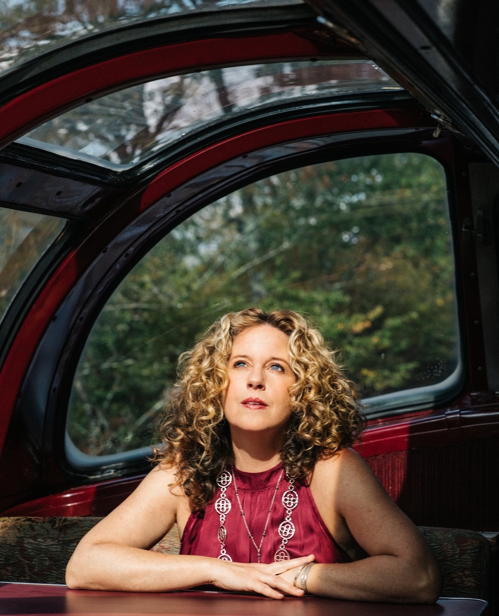 Amy Helm inside an antique bus looking up out the glass window by Amy Helm and The Helm Family Midnight Ramble in Woodstock NY