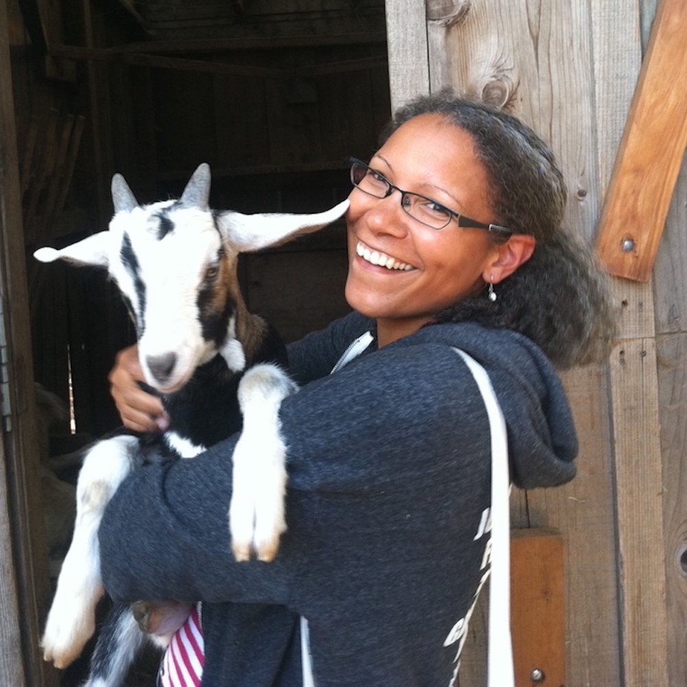 A woman farmer holding a goat at Rise and Root Farm in Chester, NY