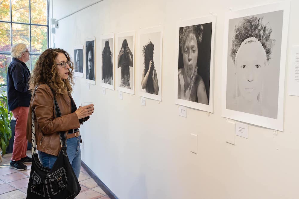 Woman is intently looking at in The West Strand Art Gallery in Kingston NY
