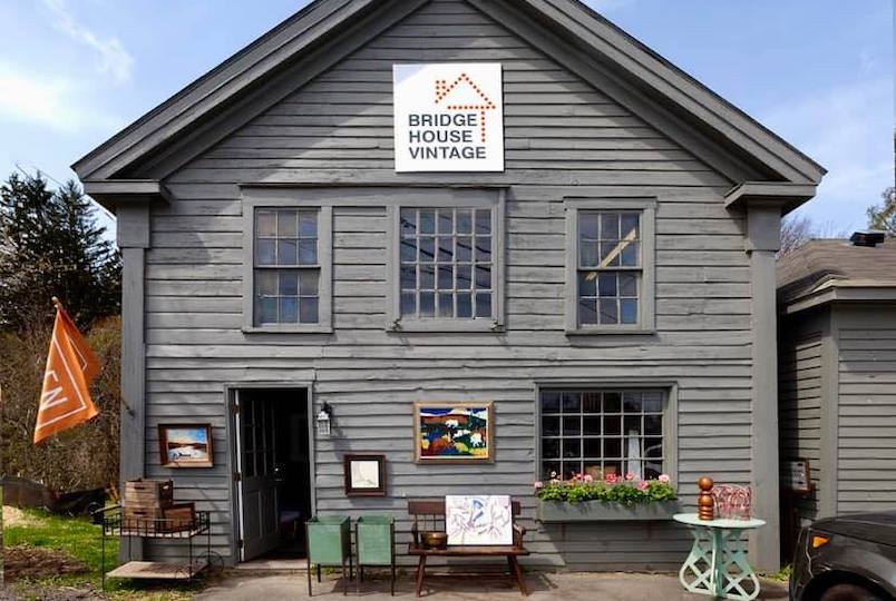 house with a sign and antiques out front by Bridge House Vintage in East Chatham NY