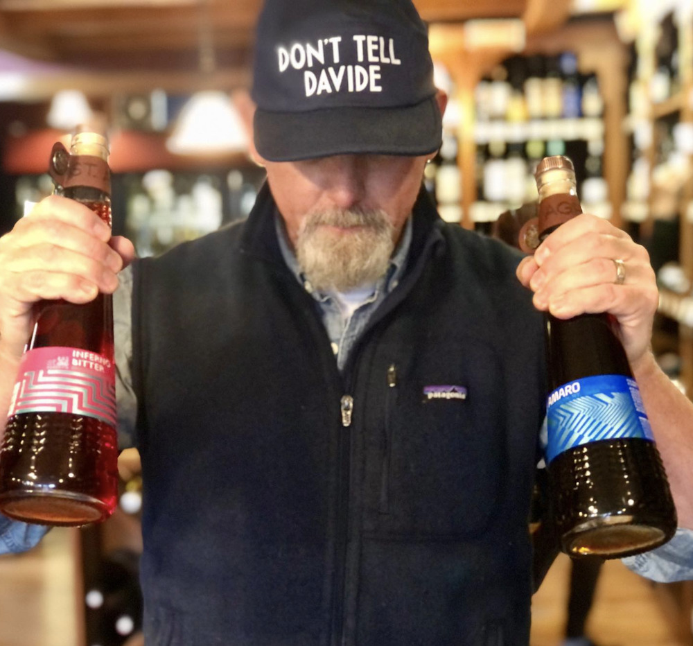 David Pinkard holding two bottles of wine at Woodstock Wine & Liquors in Woodstock, NY