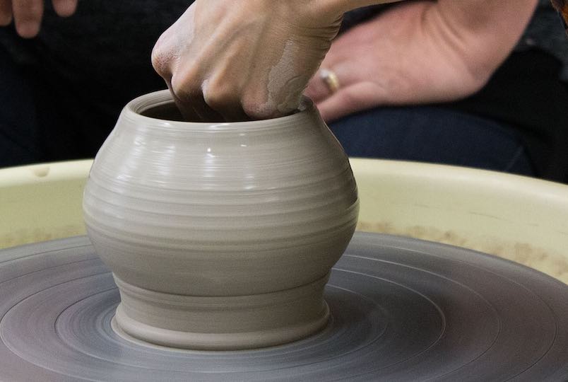 two hands making a clay cup on a pottery wheel at Fallkill Creative Works in Poughkeepsie NY