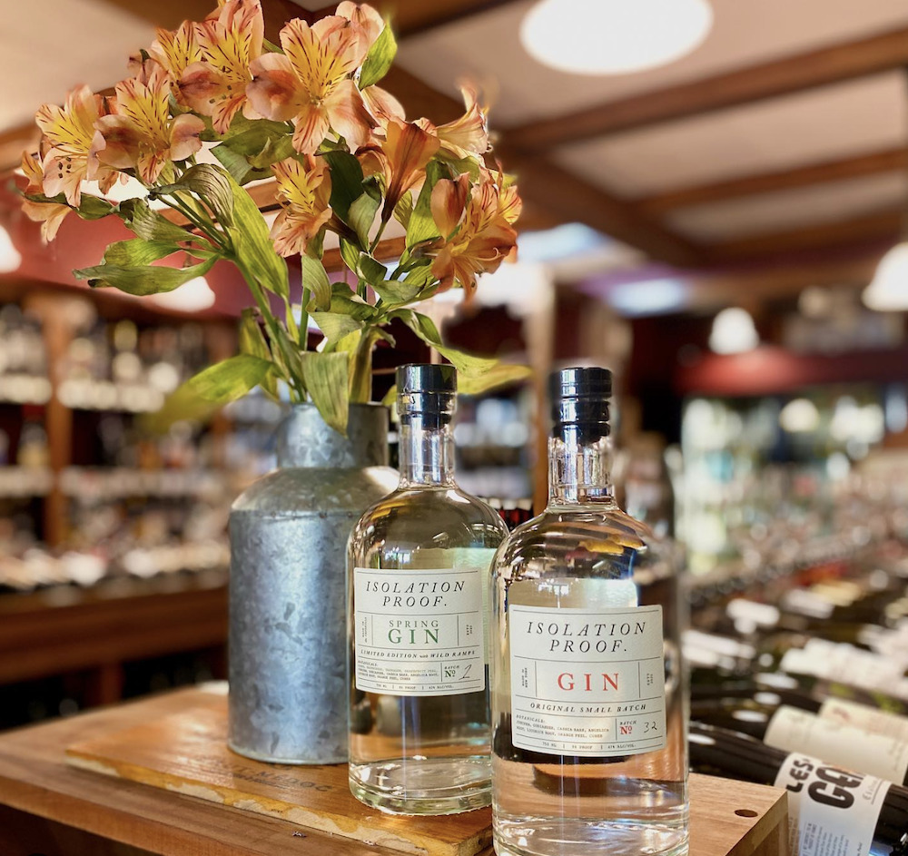 three bottles of gin and a tin can with flowers at Woodstock Wine & Liquors in Woodstock, NY