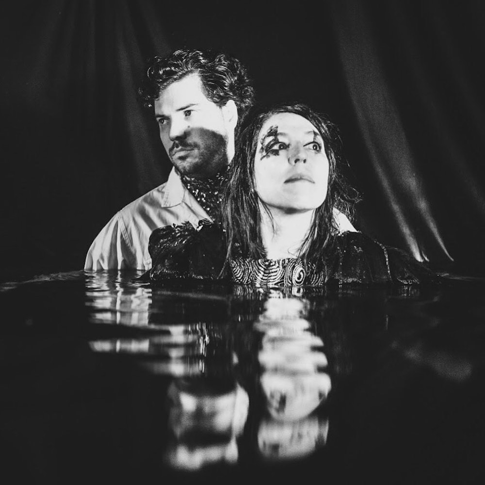 Shana Falana and her drummer posing in black water with makeup for the album cover Darkest Light
