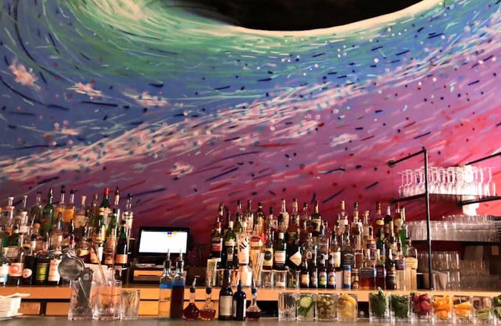 The bar and rainbow painting on the wall at The Roosevelt Bar in Beacon NY