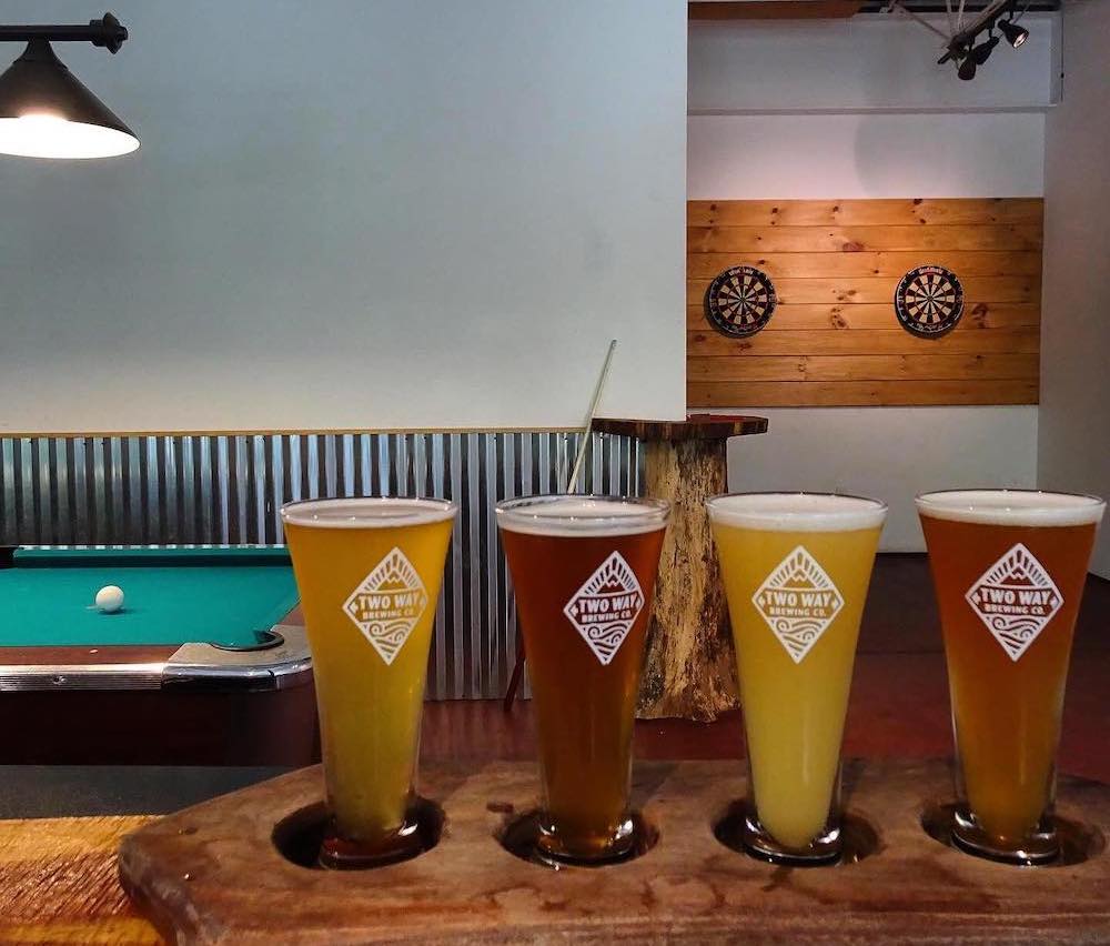 A flight of pints, pool table and dart boards in the background at Two Way Brewing Company in Beacon NY